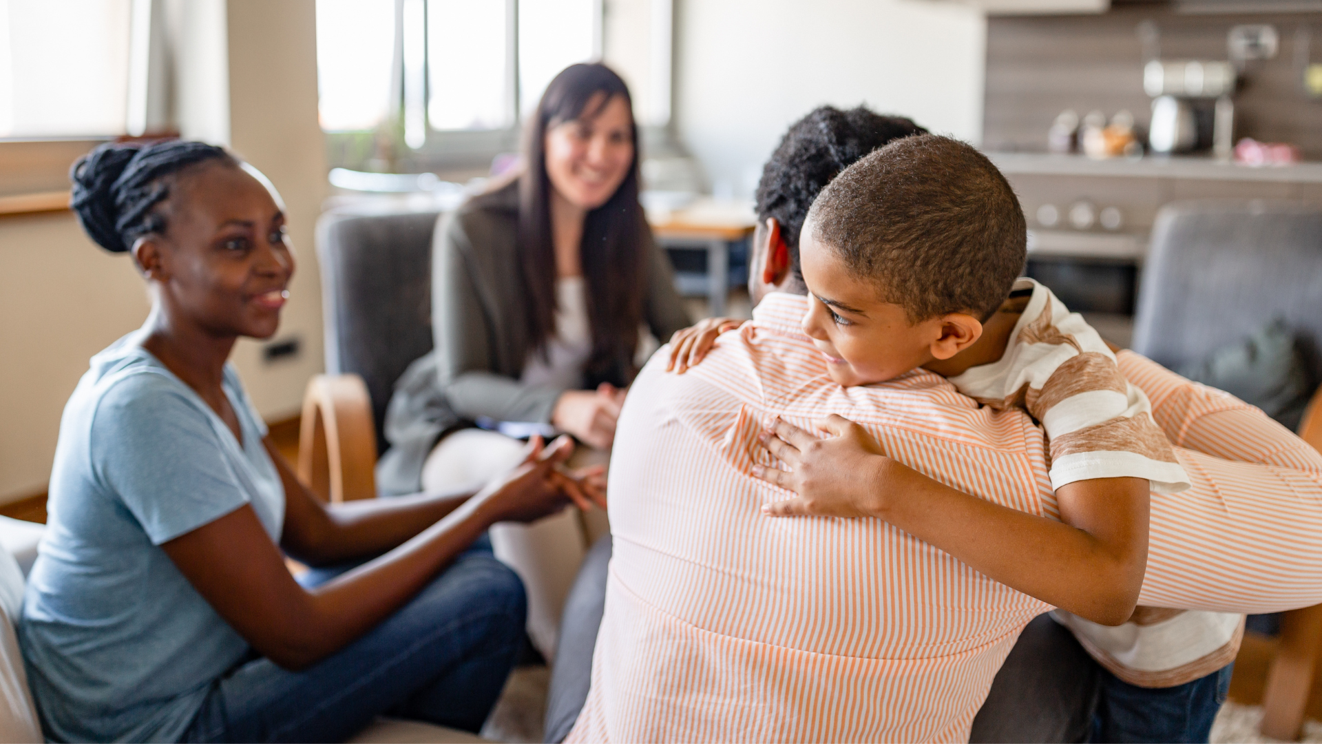 Little boy hugging a man with two smiling women looking on