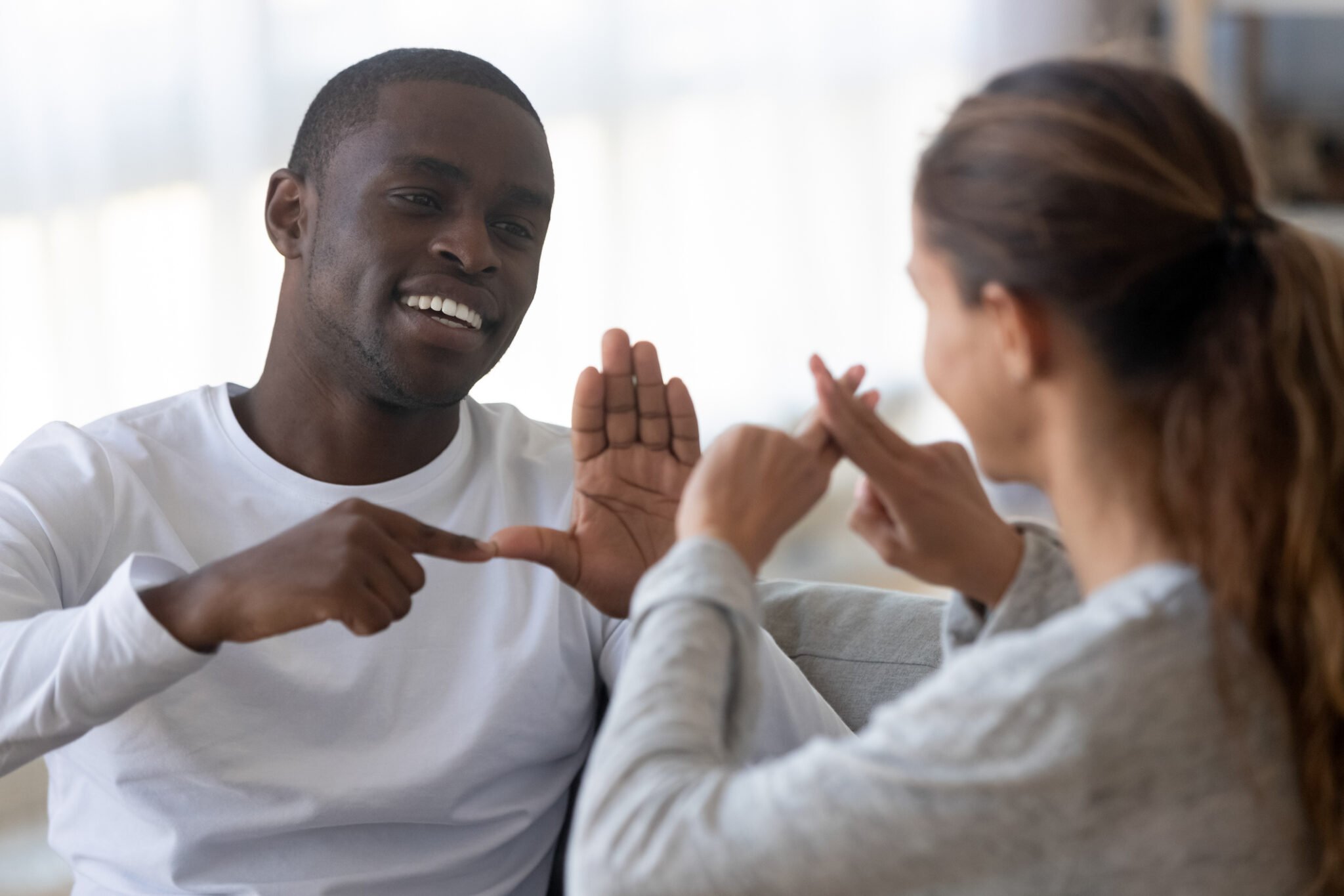Two people speaking sign language to one another