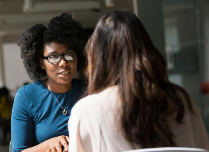 two women in conversation at a cafe table
