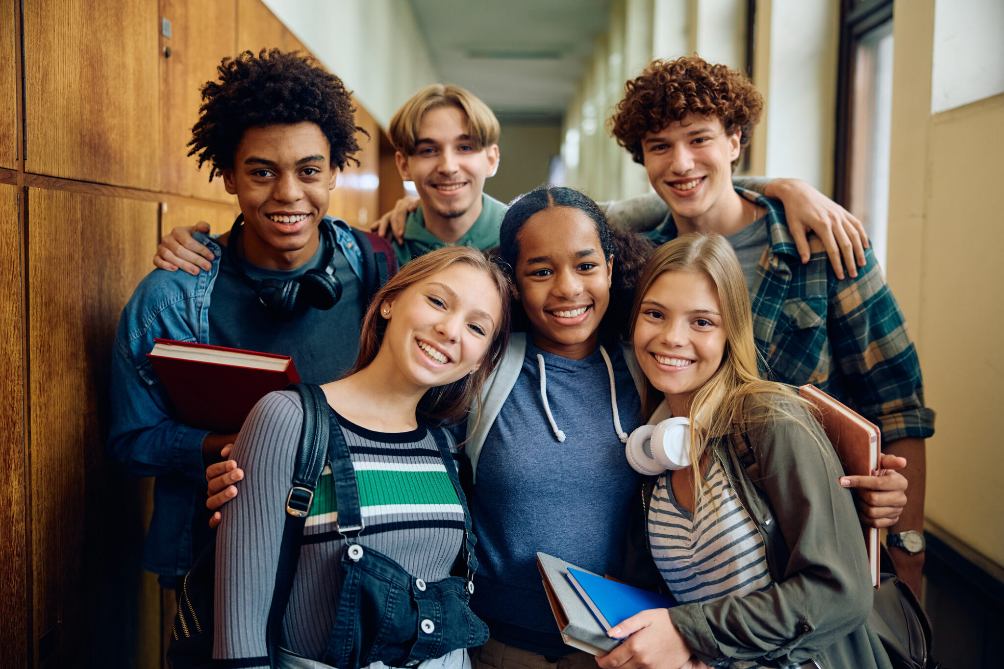 group of smiling teens in high school hallway