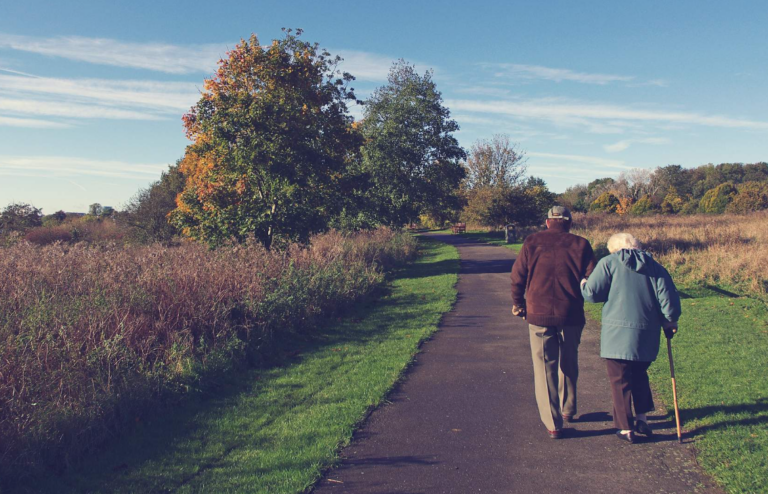 elderly couple walking on a path out in nature