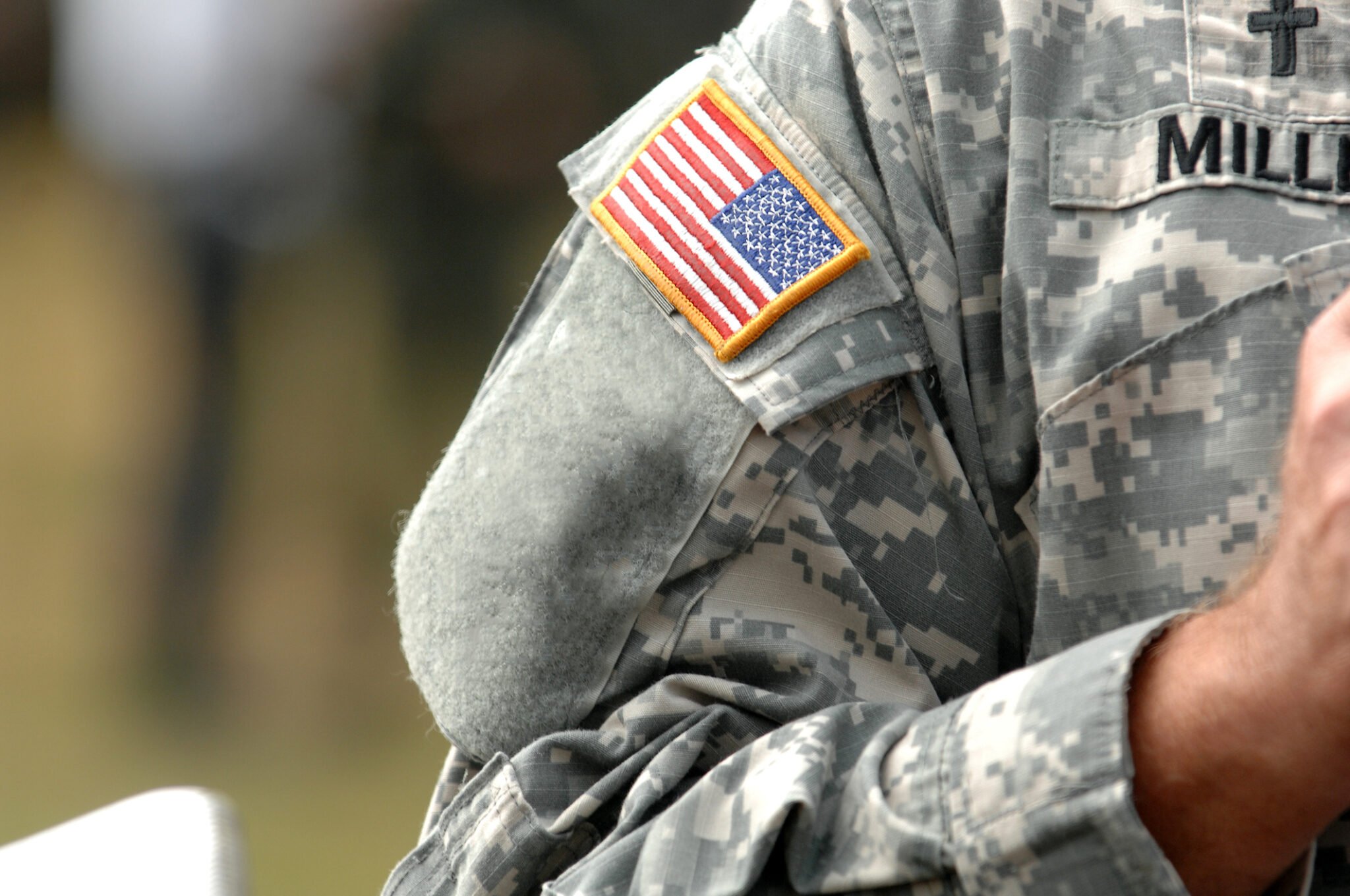 close up of person in military uniform, highlighting American flag on arm.