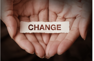 Hands cupping the word change on a piece of paper