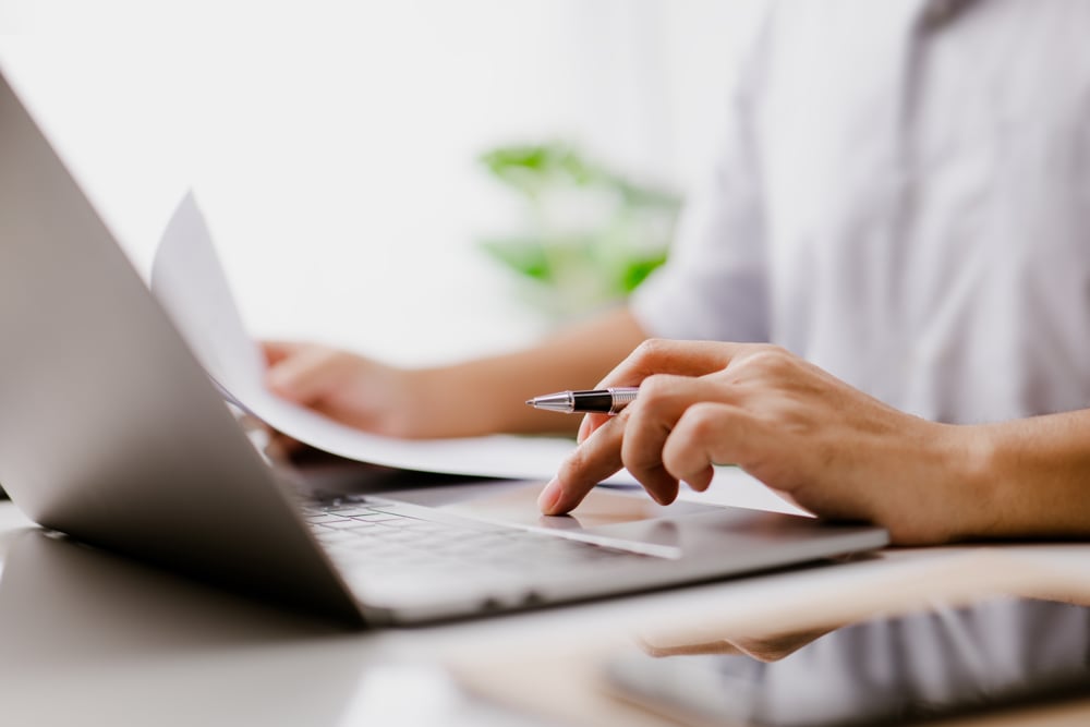 close up of person's hand as they work on a laptop
