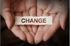 Hands cupping the word "change" on a piece of paper